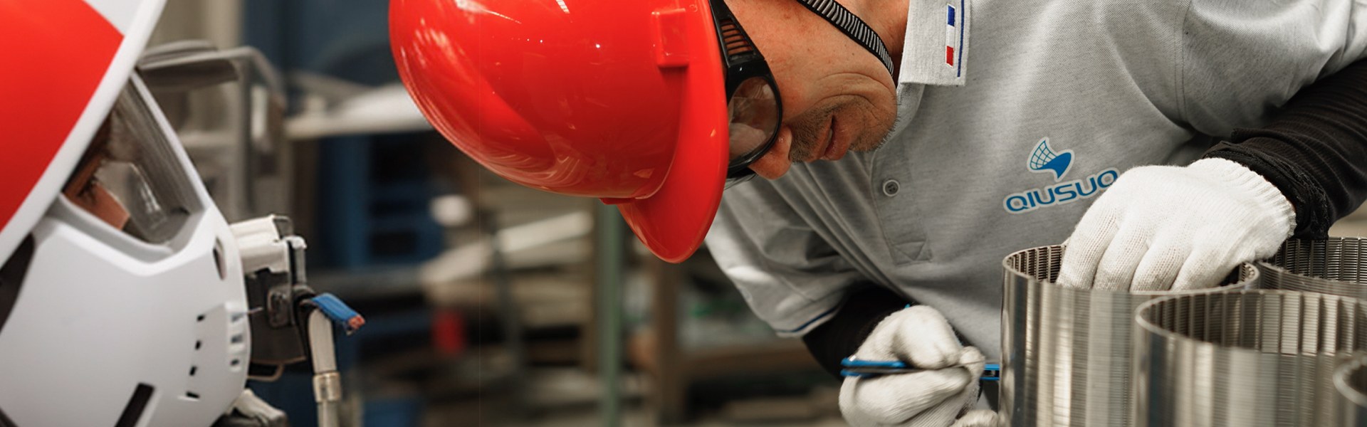 The worker wearing a safety helmet is checking the slot of wedge wire screen.
